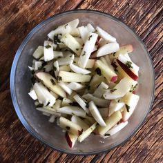 a bowl filled with sliced apples on top of a wooden table