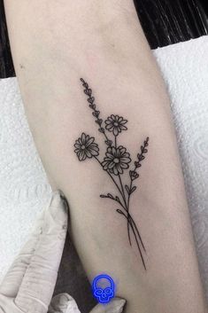 a small flower tattoo on the arm