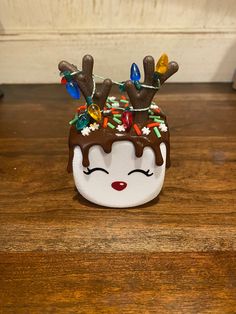 a small ceramic christmas pudding with reindeer antlers on it's head and eyes