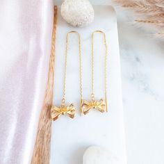 Embrace simplicity with these understated bow earrings, showcasing miniature gold-plated bow charms suspended from elegant gold threader earrings. Crafted with high-quality gold-plated threader chains, these dangling ribbon earrings are both stylish and lightweight, making them an ideal choice for everyday wear. Radiate charm and versatility with these gold ribbon ear threads, making them a perfect gift for teen girls or anyone with an affinity for the timeless elegance of bows Details:--------- Chic Dangle Threader Earrings Gift, Chic Threader Drop Earrings As Gift, Adjustable Gold Jewelry With Decorative Bow, Gold Plated Drop Threader Earrings As Gift, Dainty Gold Jewelry With Ribbon, Gold Dainty Bow Earrings, Gold Dainty Earrings With Bow, Dainty Gold Earrings With Bow, Gold-plated Threader Earrings As A Gift