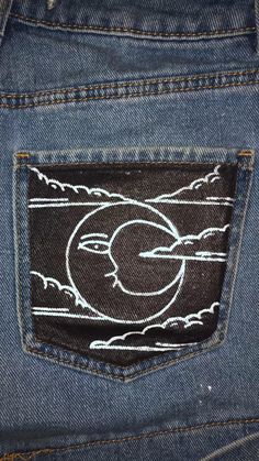 the back pocket of a pair of jeans with an image of a sun and clouds on it