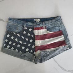 Purchased And Never Worn. 10.5” Inseam, About 16” Across The Waist Band When Laid Flat. Americana Style Denim Jean Shorts For Spring, Americana Style Denim Jean Shorts, Americana Denim Jean Shorts For 4th Of July, Trendy Cotton Jean Shorts For 4th Of July, 4th Of July Denim Cutoff Jean Shorts, Denim Shorts With American Flag Print For Spring, Denim American Flag Print Shorts For Spring, American Flag Print Denim Shorts For Spring, Trendy American Flag Print Cotton Shorts