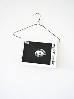 a photo hanging from a clothes hanger on a white wall