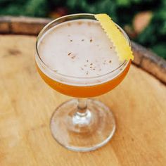 a glass filled with orange juice on top of a wooden table