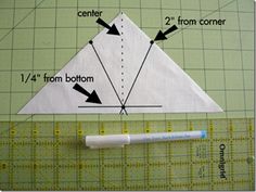 an origami triangle is shown on a cutting board with rulers and markers