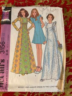 two women's dresses and one woman's dress sewing pattern on a red blanket