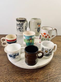 coffee cups and mugs are arranged on a tray