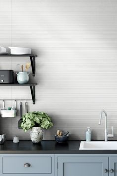 a kitchen with gray cabinets and white walls