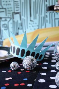 a table topped with disco balls and a paper crown