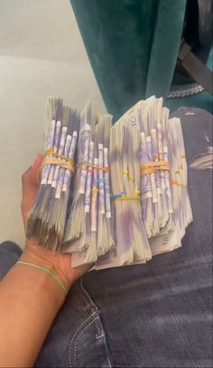 a person holding several bundles of money in their hand