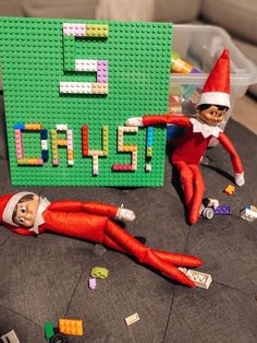 an elf laying on top of a table next to a lego sign