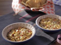 two bowls filled with food sitting on top of a table