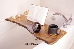 an open book on a wooden shelf next to a cup