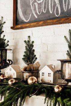 christmas decorations on a mantel in front of a chalkboard