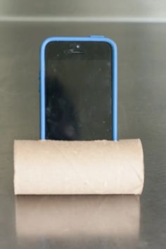 a cell phone sitting next to a roll of toilet paper on top of a table