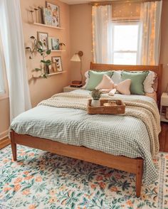 a bed sitting in a bedroom next to a window covered in curtains and pillows on top of a rug