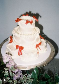 a three tiered wedding cake with red bows