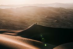 the sun shines brightly on sand dunes