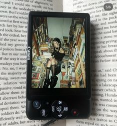 a cell phone sitting on top of a book with an image of a woman in black