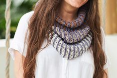 a woman with long brown hair wearing a blue and white crocheted cowgirl neck scarf