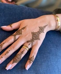 a woman's hand with henna tattoos on it