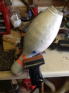 an old blow dryer sitting on top of a work bench next to other tools