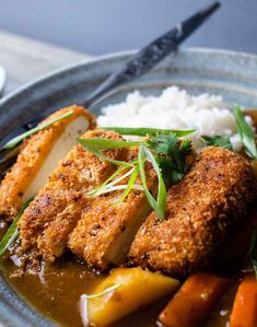 crispy panko - crusted tofu steak on a plate with rice and vegetables