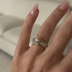 a woman's hand with a diamond ring on it