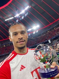 a man holding up a trophy in front of a crowd at a sporting event,