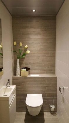 a white toilet sitting in a bathroom next to a sink