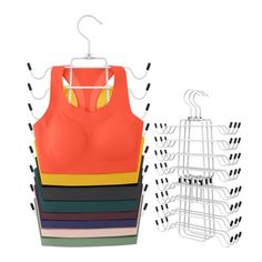 an orange top hanging on a rack next to several different colors of bras and pants