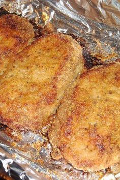 three pieces of meat cooking in a frying pan