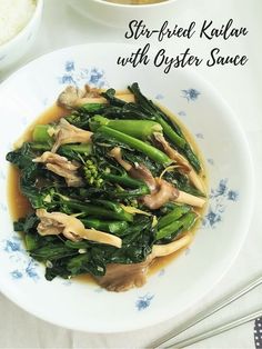 stir fried kale with oyster sauce in a white bowl on a blue and white plate