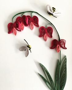 paper flowers and leaves arranged on a white surface