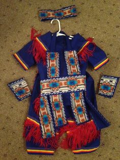 an infant's native american outfit with matching headbands and booties is laying on the floor