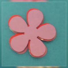 a pink and red flower shaped object on a blue surface