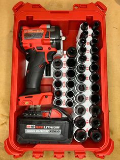 a red tool box filled with lots of black and white cups next to a cordless drill