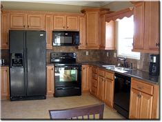 a kitchen with wooden cabinets and black appliances