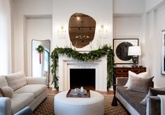 a living room filled with furniture and a fire place in front of a fireplace covered in greenery