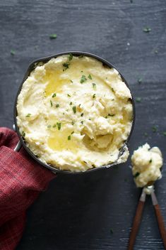 a bowl filled with mashed potatoes on top of a wooden table