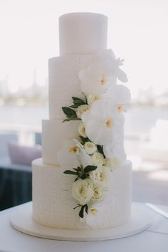 a wedding cake with white flowers and greenery