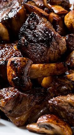 some meat and mushrooms on a white plate