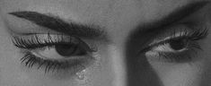 black and white photograph of woman's eye with teary lashes