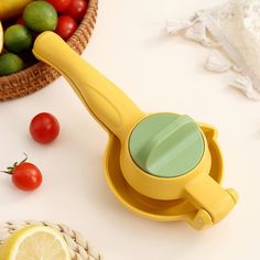 a lemon slicer sitting on top of a table next to some fruit and vegetables