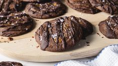 chocolate cookies with icing and sprinkles on a wooden board