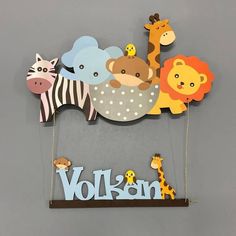 a wooden sign with animals, giraffes and zebras hanging from it's sides