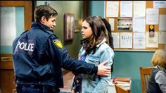 a police officer talking to a girl in a classroom