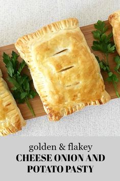 three golden and flaky cheese onion and potato pasties on a cutting board