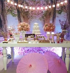 a table topped with pink umbrellas and cakes