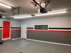 an empty room with red and black stripes painted on the wall next to a white door